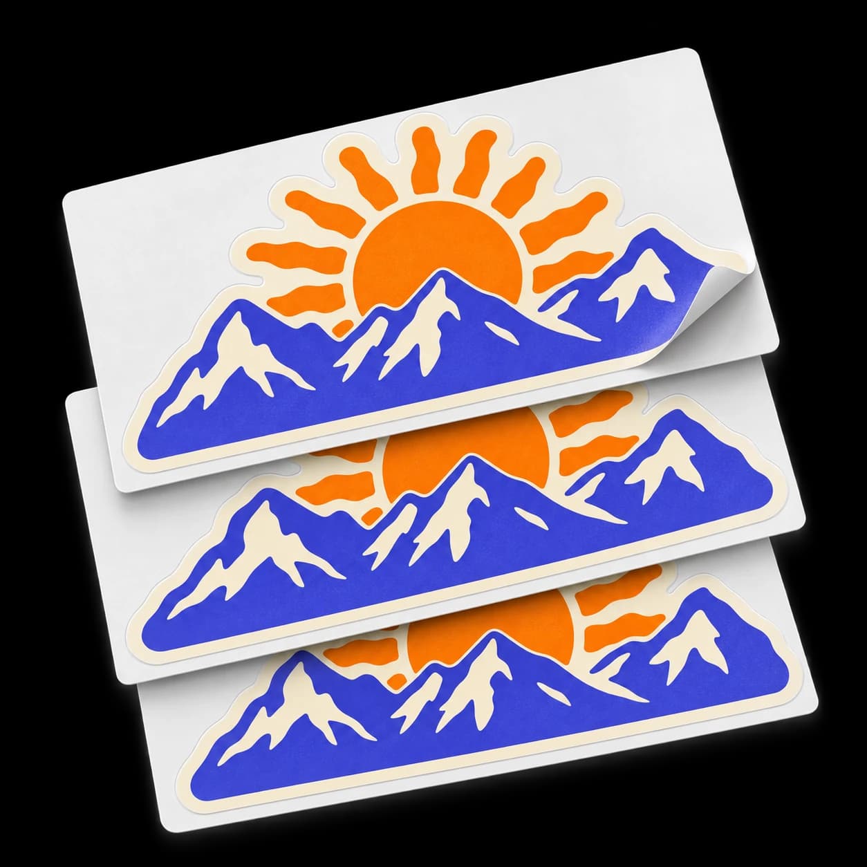 Stack of purple mountain and orange sun kiss-cut stickers on larger white rectangular backing sheets