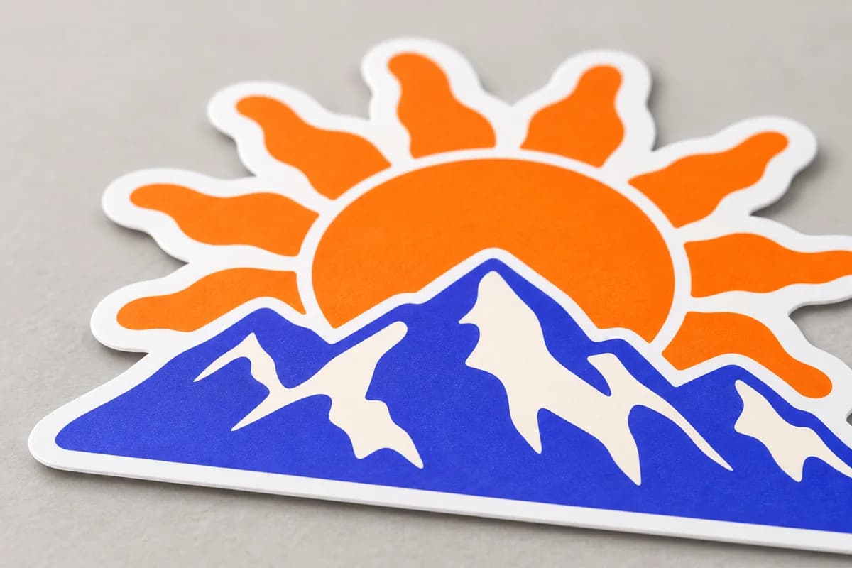 Close-up of an orange and purple mountain-shaped sticker with a matte surface